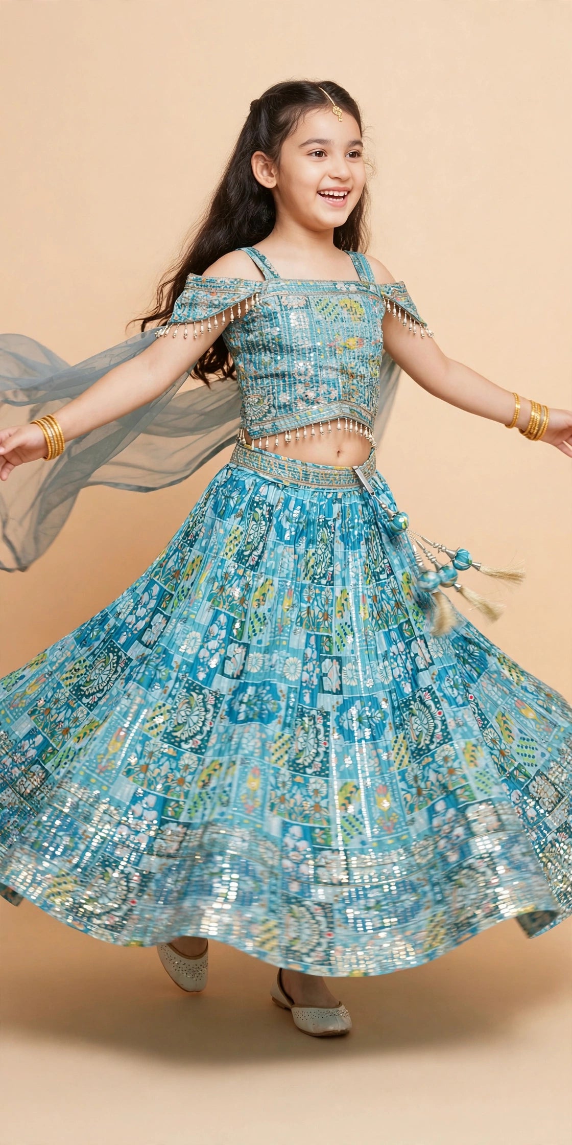 Close-up of silver clip latkan with blue printed fabric balls and gold tassels