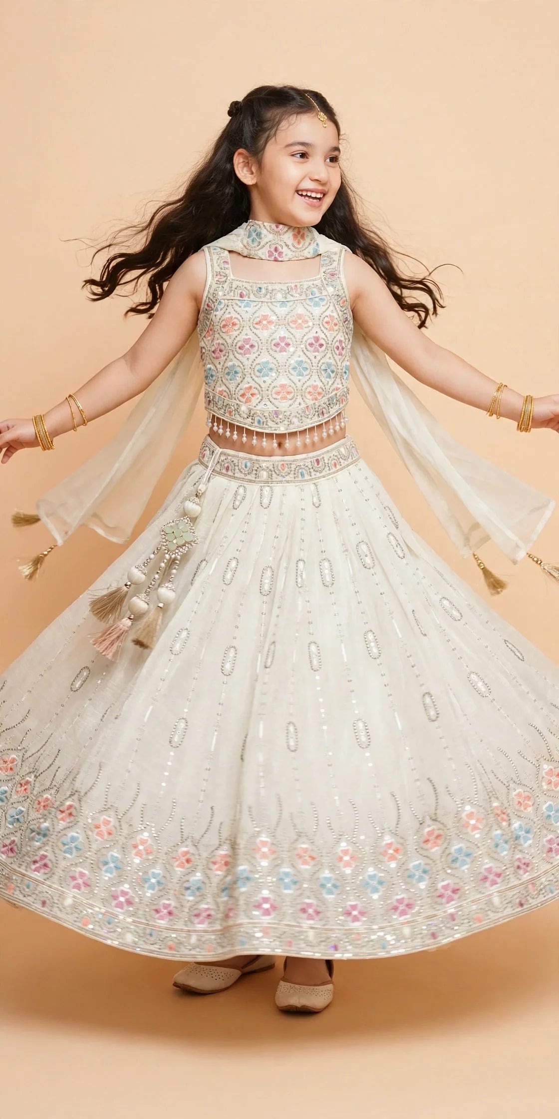 Girls ivory lehenga with pastel floral embroidery and pearl-drop choli fringe
