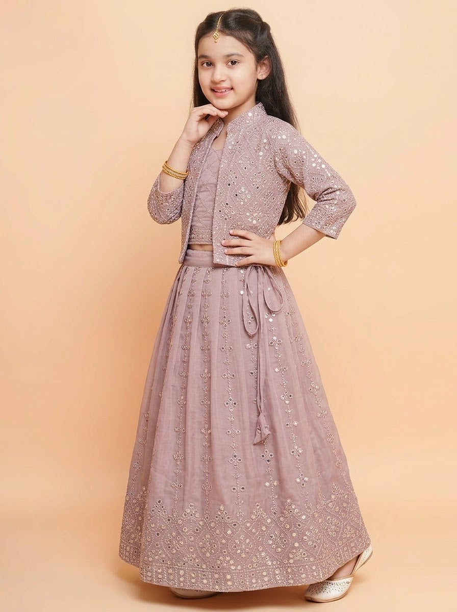 Seated view of girls mauve lehenga showing decorative skirt border