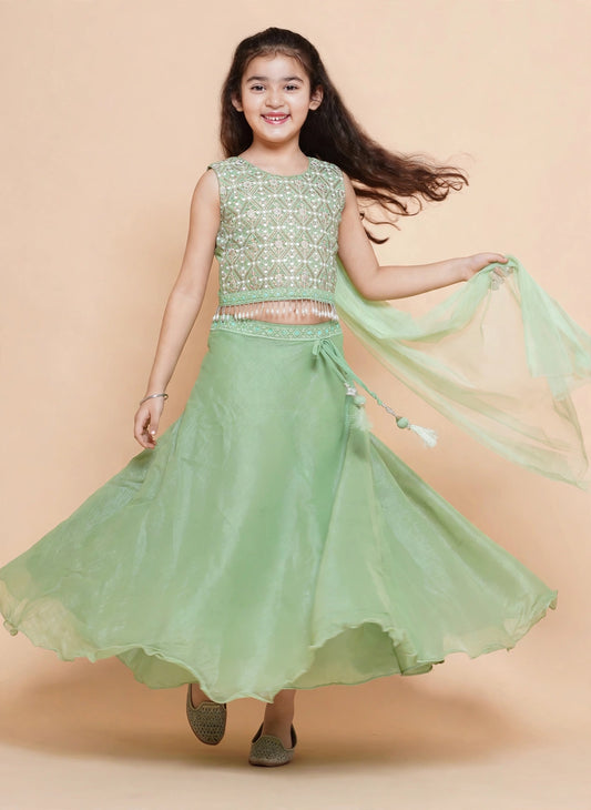 Front view of pista green lehenga choli with matching dupatta and tassel waist ties