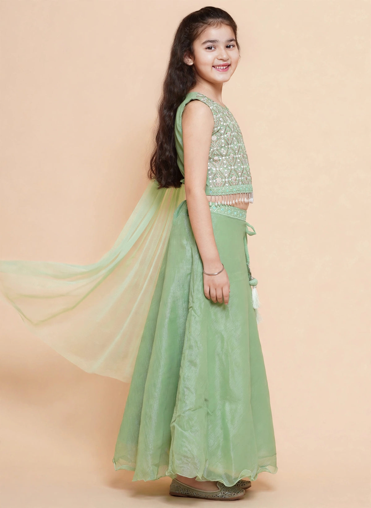 Close-up of diamond-lattice embroidery and pearl-drop fringe on pista green choli