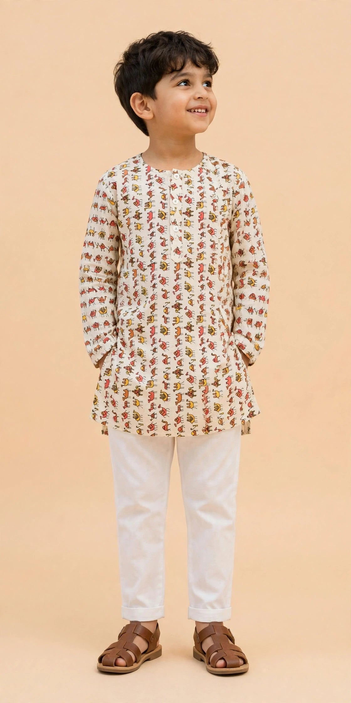 Boy waving in cream camel print kurta pajama festive outfit