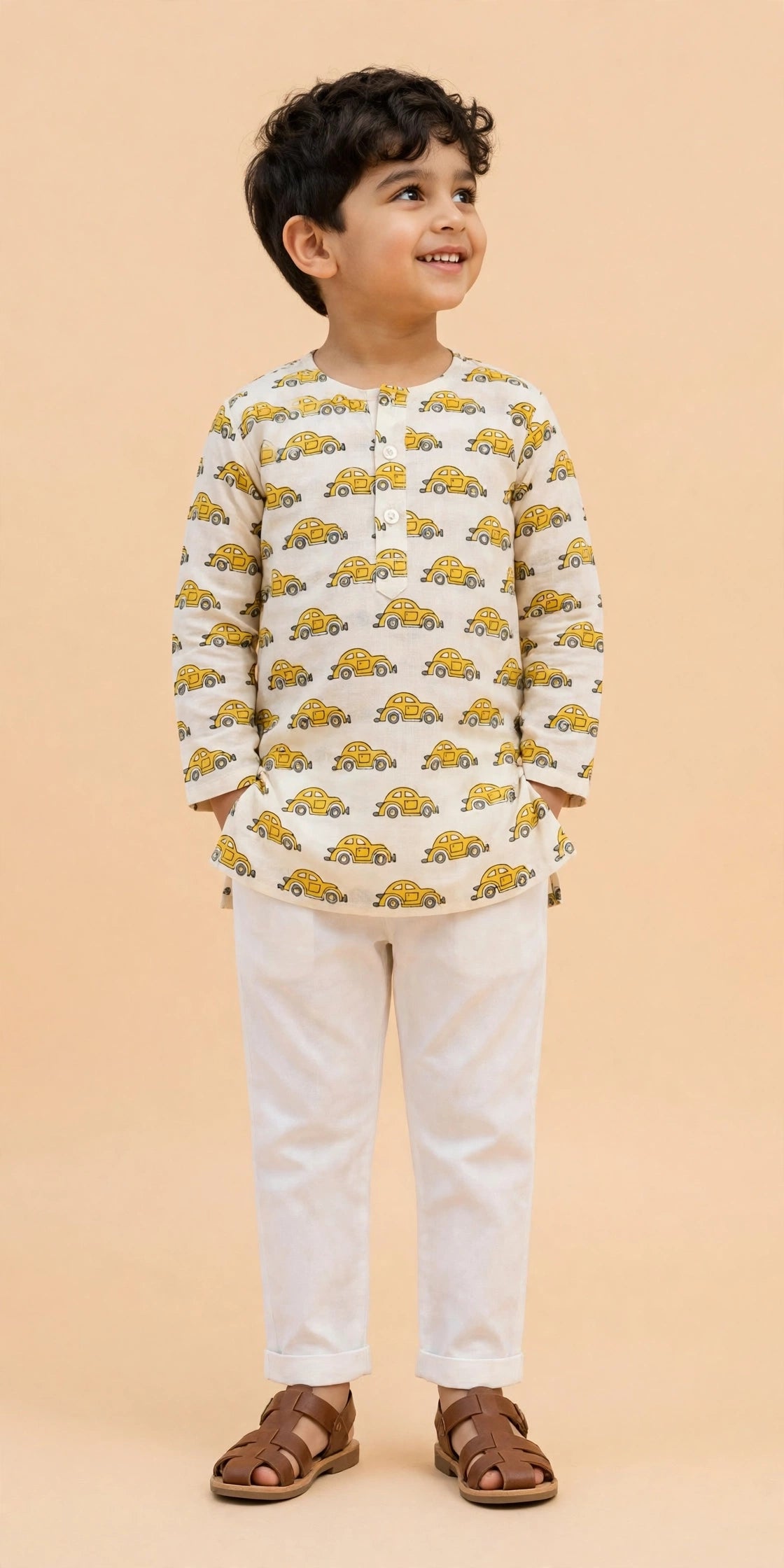Side view of boy walking in cream car print kurta and white pajama