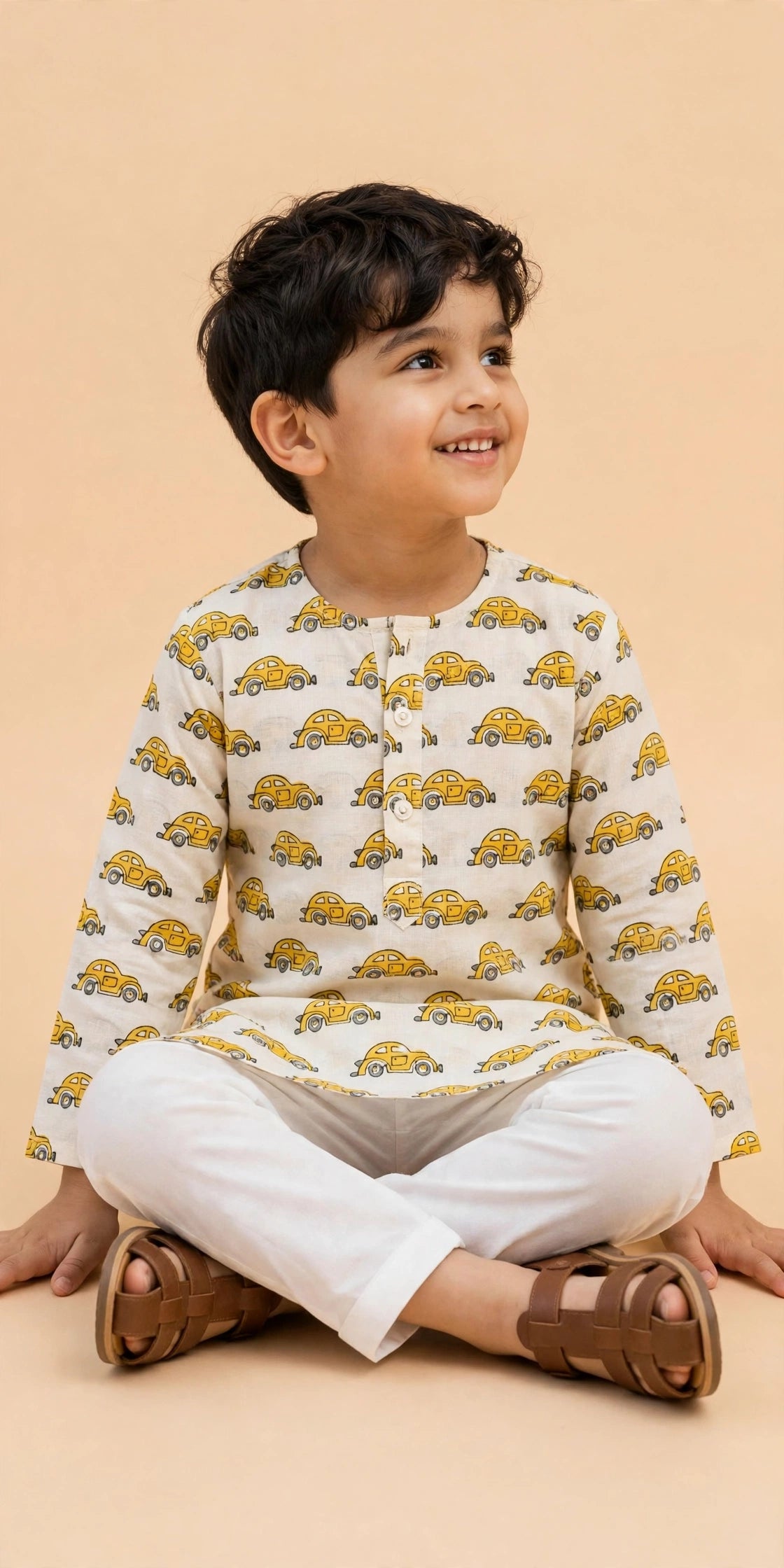Front view of boys cream yellow car print kurta and white pajama set