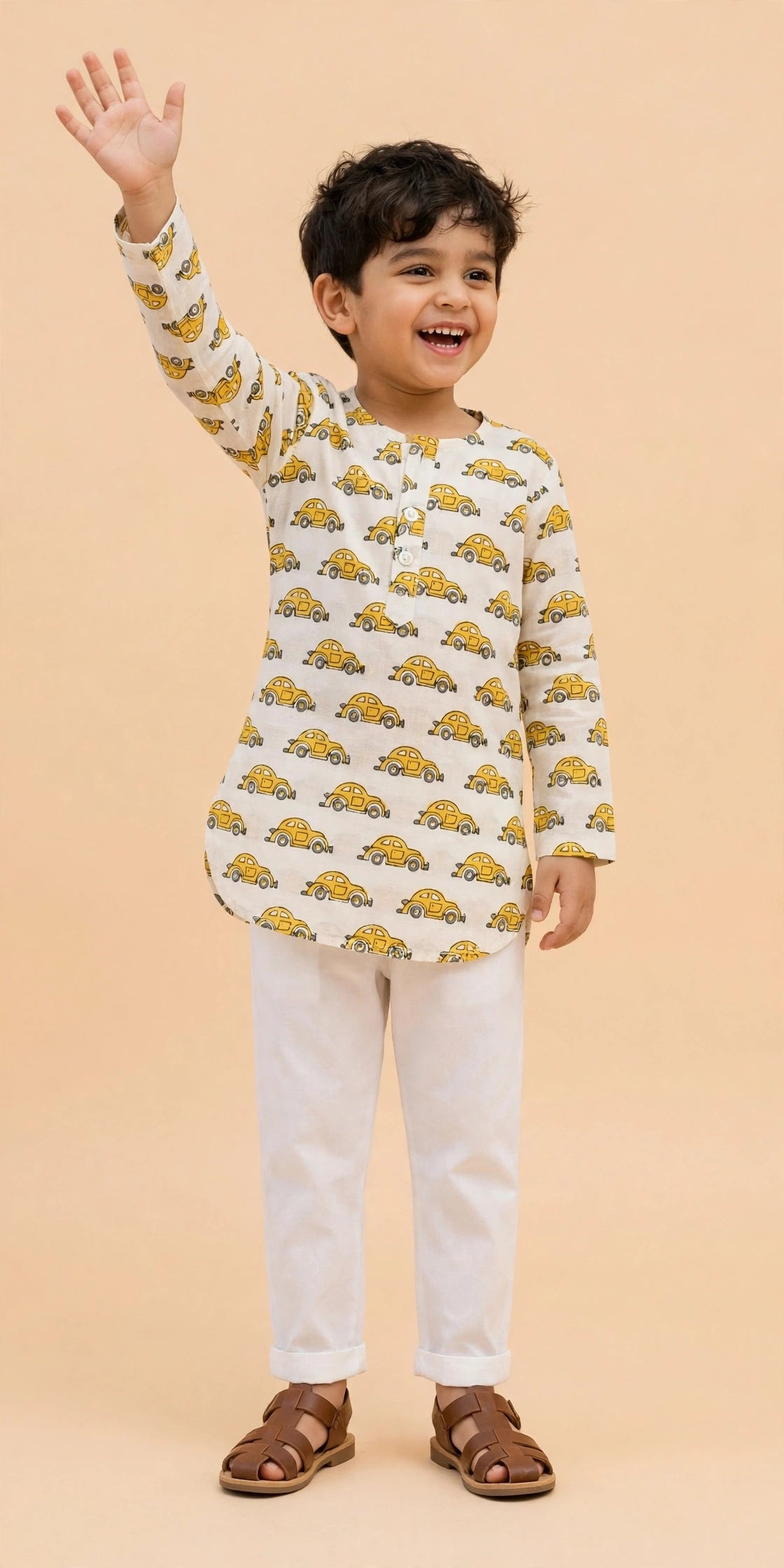 Boy standing with arms crossed in cream car print kurta and white pajama