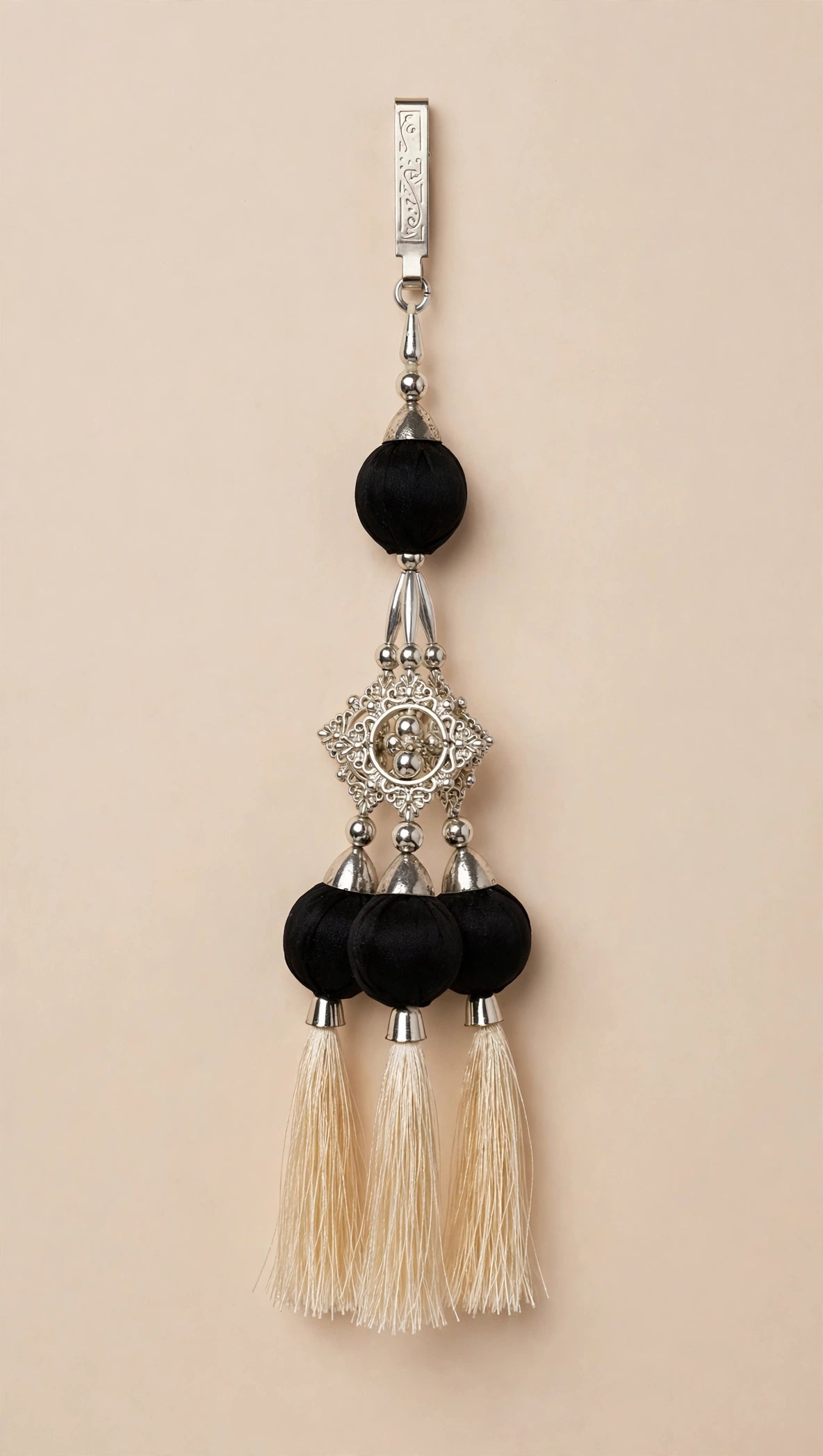 Statement latkan with silver clip, black fabric balls, filigree pendant and three cream tassels