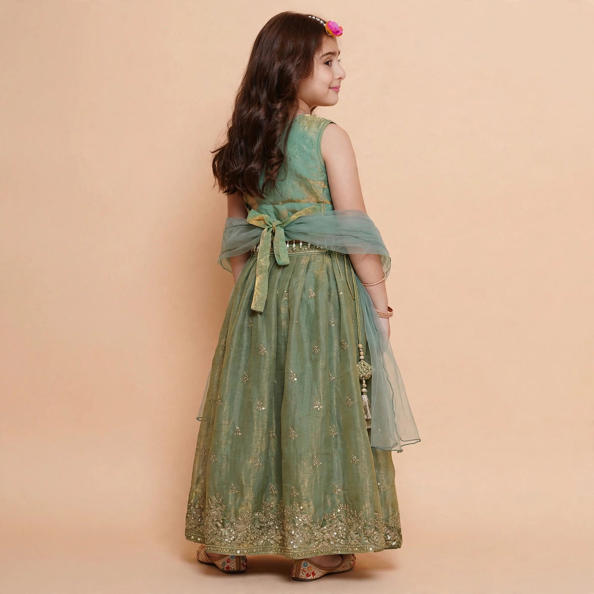 Girls sage green embroidered lehenga choli holding matching dupatta
