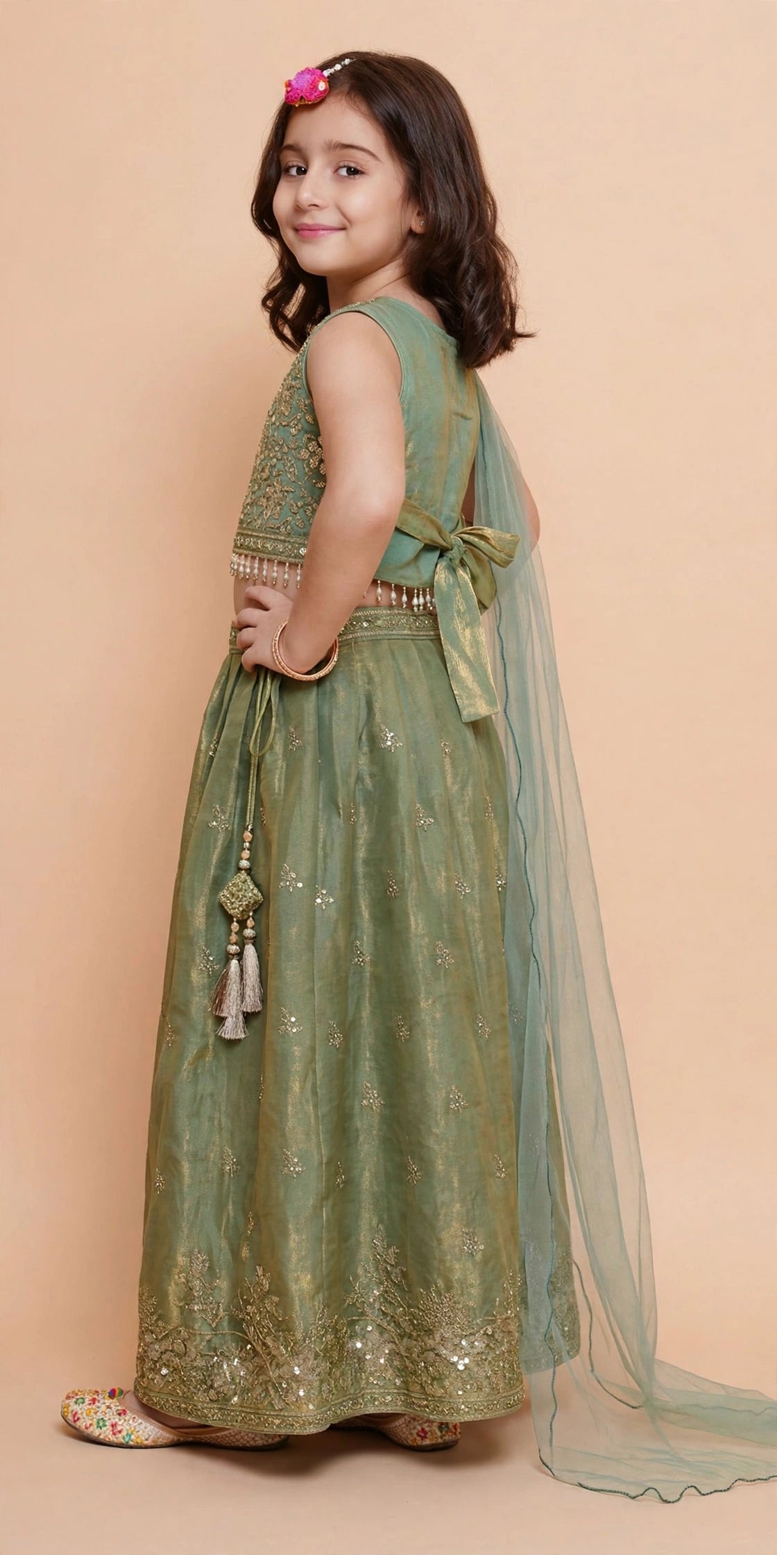 Girls sage green tissue lehenga twirling with sheer dupatta